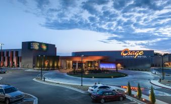 "a large building with the word "" oasis "" on it and a parking lot in front of it" at Osage Casino Hotel
