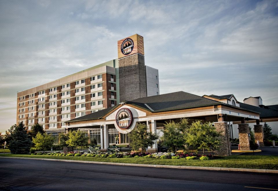 a large hotel building with a clock tower , situated on a busy city street near a parking lot at Akwesasne Mohawk Casino Resort