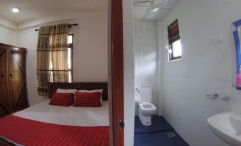 a bed with red and white bedding is in a room with a window and a toilet at Heaven Rest