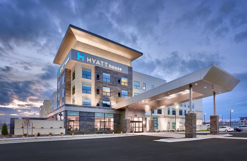 a modern hotel building with the hyatt brand logo , surrounded by a parking lot and a parking lot entrance at Hyatt House Provo/Pleasant Grove