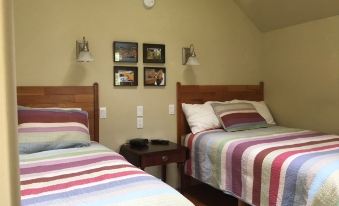 a bedroom with two twin beds , a nightstand between them , and pictures on the wall at Garden Studio