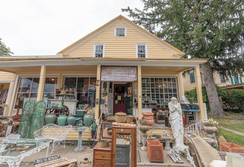 a yellow house with a large collection of antiques on display in front of it at Van Winkle Inn