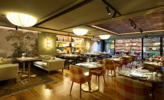 a restaurant with wooden floors and chairs , tables , and a bar area decorated with flowers at Barceló Oviedo Cervantes