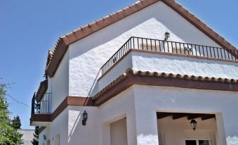 a white house with a brown roof and two balconies is shown against a clear blue sky at Julian