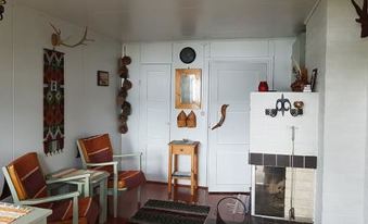 a cozy living room with a fireplace , wooden furniture , and various decorations on the walls at Simola