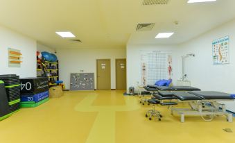 In the spacious room, there are multiple pieces of exercise equipment on the floor, while an empty locker is situated in the front at Shanghai Baoan Hotel