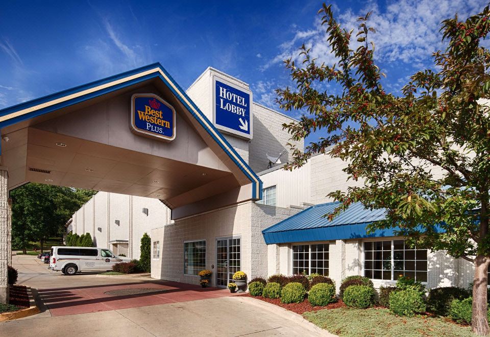 a best western hotel with its entrance and signage , surrounded by trees and clear skies at Best Western Plus Longbranch Hotel  Convention Center