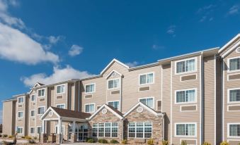 a modern hotel building with beige exterior and stone accents , set against a blue sky at Microtel Inn & Suites by Wyndham Sweetwater