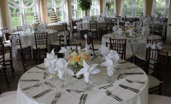 a well - decorated dining room with tables covered in white tablecloths and set for a formal event at Beau Rivage Golf and Resort