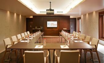 a conference room set up for a meeting , with chairs arranged in rows and a projector on the wall at The Brando