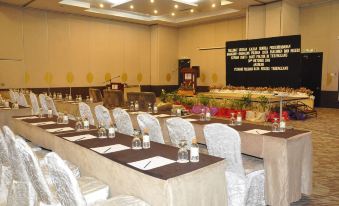 a conference room set up for a meeting , with several tables and chairs arranged in rows at Permai Hotel Kuala Terengganu