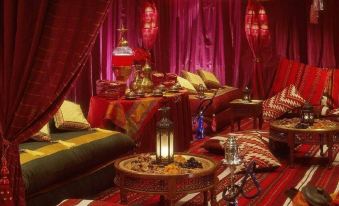 a room with red curtains , gold accents , and various items such as a tray and a table at Four Seasons Hotel Cairo at the First Residence