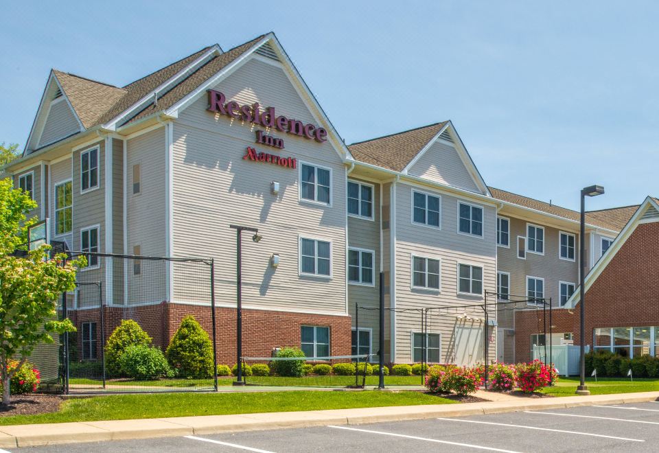 a large hotel building with multiple stories , located on a busy city street with trees and buildings in the background at Residence Inn Waynesboro