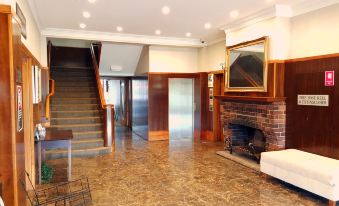 a spacious living room with a fireplace and a staircase leading to the second floor at Wallacia Hotel