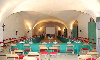 a large , empty room with rows of chairs and tables set up for a meeting or event at Chateau de la Bourdaisiere