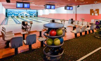a bowling alley with multiple bowling lanes and a variety of bowling balls on racks at Squire Resort at The Grand Canyon, BW Signature Collection