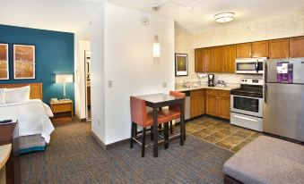 a kitchen and dining area in a hotel room with a kitchenette , microwave , refrigerator , and table at Residence Inn Saddle River