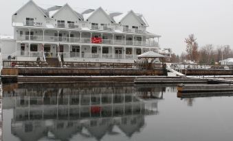 a large white building with a red flag on top , reflected in the water below at Sportsman's Inn Resort & Marina