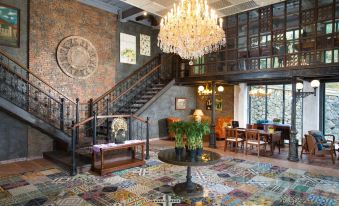 a large , ornate foyer with a staircase leading to the second floor , adorned with a chandelier and artwork at Plataran Bromo