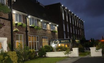 "a brick building with a sign that says "" parkfield hotel "" is lit up at night" at The Park Hotel