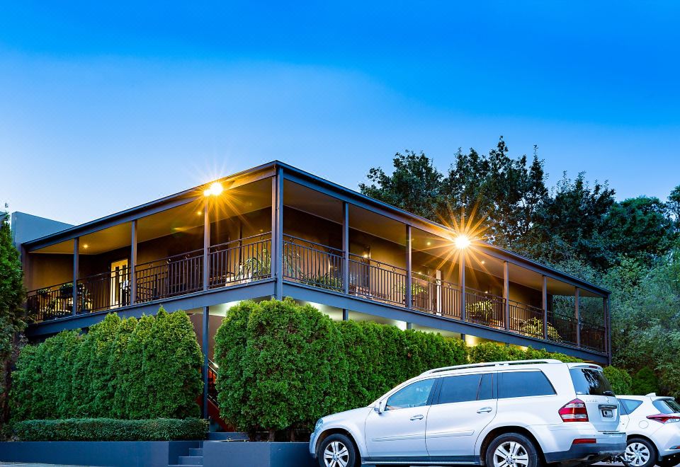 a large house with a car parked in front of it and bushes surrounding the area at Barkly Motorlodge