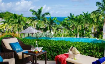 a luxurious outdoor area with a pool , lounge chairs , and a teddy bear on a table at Residences at Nonsuch Bay Antigua - Room Only - Self Catering