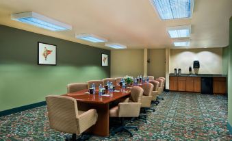 a conference room with a wooden table , chairs , and water bottles set up for a meeting at Oxford Suites Pendleton