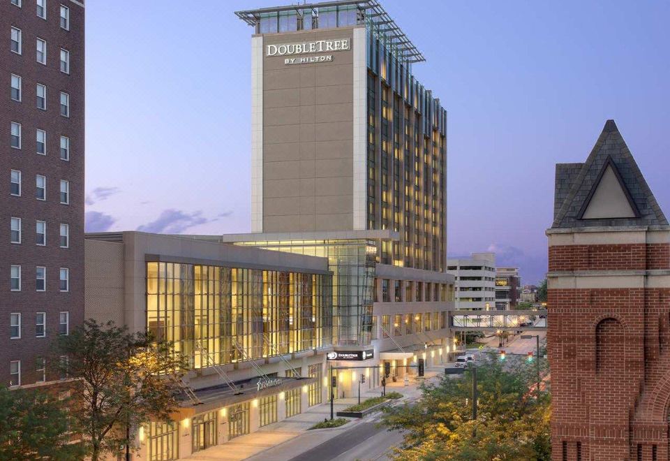 "a tall building with the word "" dubuque "" on it is surrounded by trees and other buildings" at DoubleTree by Hilton Cedar Rapids Convention Complex