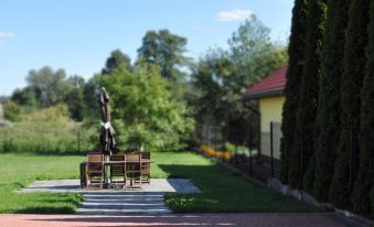 a sculpture of a person on a bench in a park setting , surrounded by trees and bushes at Best East