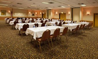 a large conference room filled with rows of tables and chairs , ready for a meeting or event at Ramada by Wyndham Clarion