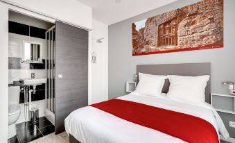 a modern bedroom with a white bed , red bedding , and a large painting on the wall at Paris Hotel
