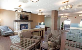 a large hotel lobby with various seating options , including couches and chairs , as well as a fireplace at Riverview Inn