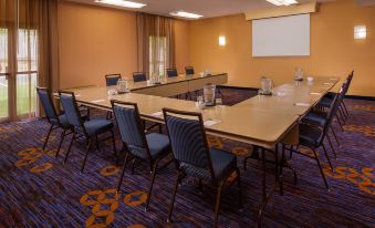 a conference room set up for a meeting , with chairs arranged in a semicircle around a table at Courtyard Richmond West