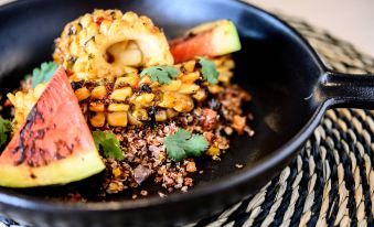 a black bowl filled with a variety of ingredients , including corn , watermelon , and other vegetables at Riviera Marriott Hotel la Porte de Monaco