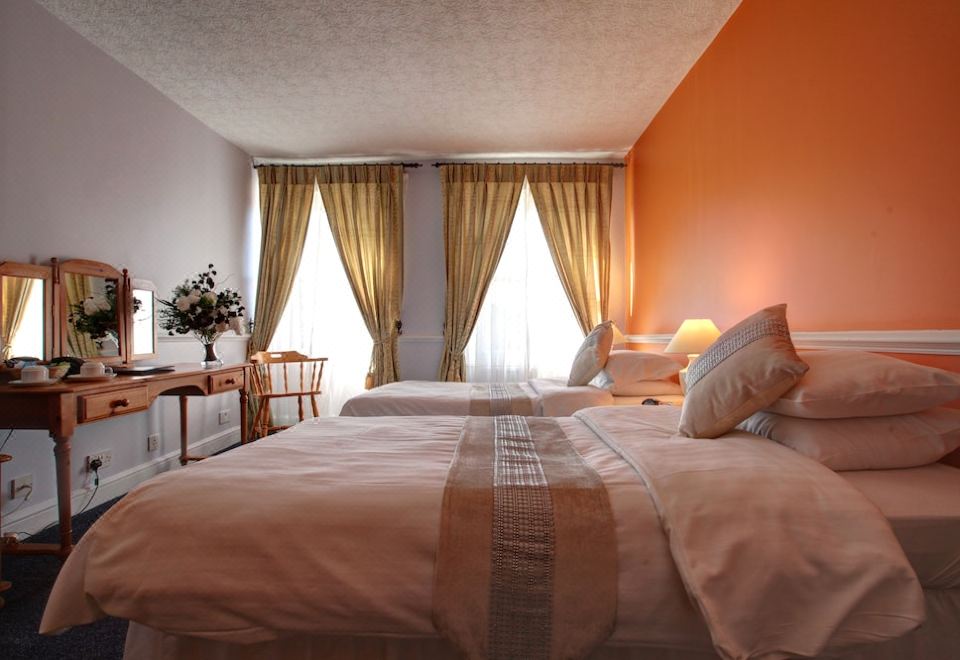 a hotel room with two beds , one on the left and one on the right side of the room at The Imperial Hotel