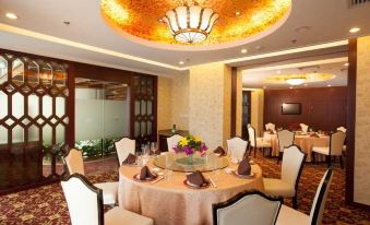 A spacious room is prepared with tables and chairs arranged in the center for an event or formal occasion at Merchant Marco Hotel