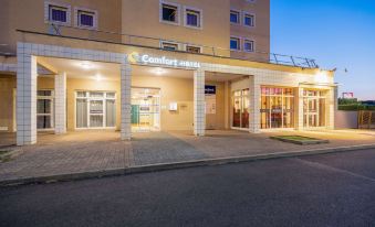 "a hotel entrance with a sign that reads "" comfort suites "" and a view of the street below" at Comfort Hotel Montlucon