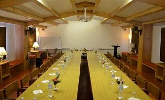 A spacious room is arranged with long tables and chairs for an event or meeting at Haatiban Resort