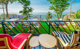 a balcony overlooking the ocean , with several lounge chairs and umbrellas placed on the balcony at Play Phala Beach Rayong