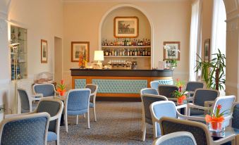 a hotel lobby with a bar area , where several people are seated and enjoying their drinks at Grand Hotel Menaggio