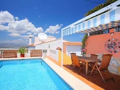 a house with a large pool surrounded by a patio , and a dining table and chairs nearby at Joli Joli Photo