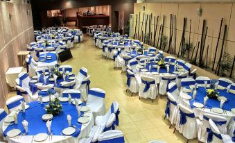 a large banquet hall filled with round tables and chairs , all set up for a formal event at Hotel St. George