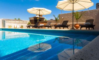 a large outdoor swimming pool surrounded by lounge chairs and umbrellas , providing a relaxing atmosphere at Hotel Royal