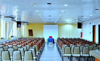 an empty conference room with rows of chairs and a large screen at the front at Taj Mahal Hotel