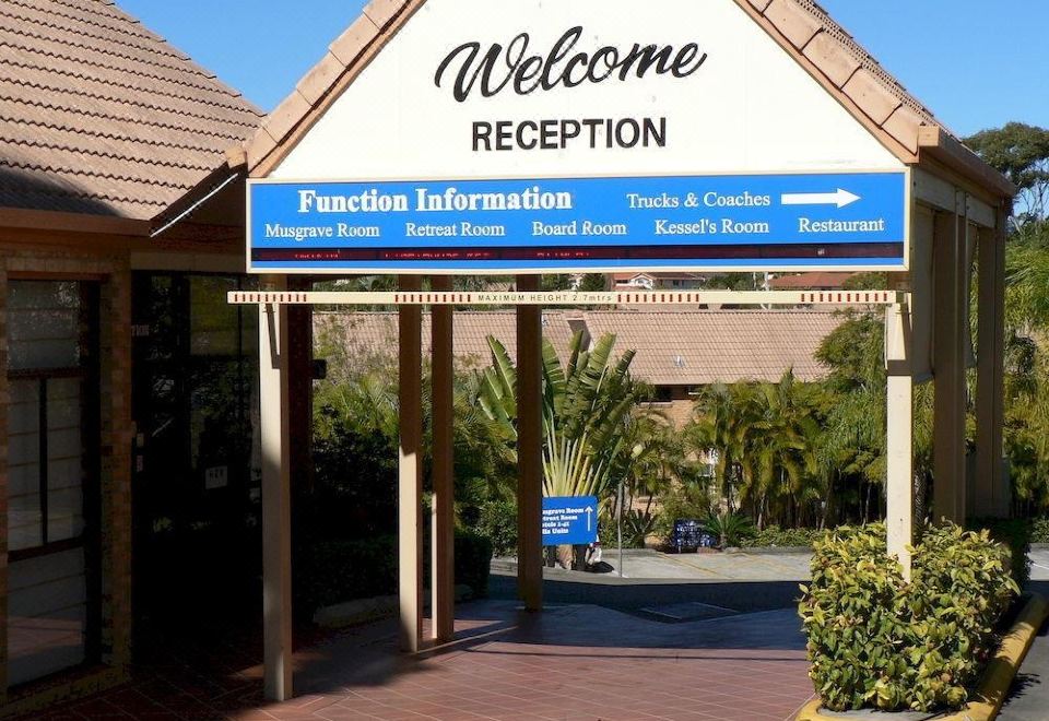 "a blue sign with white text that reads "" welcome reception "" is displayed above a building entrance" at Quality Hotel Robertson Gardens