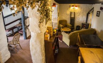 a room with a large tree in the middle , surrounded by various furniture and decorations at The Cuckoo Brow Inn