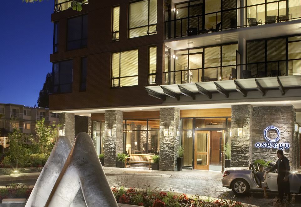 a hotel entrance with a large stone fountain and a car parked in front of it at Oswego Hotel