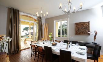 a large dining room with a long table set for a meal , surrounded by chairs at Villa la Tosca