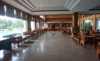 a large , empty room with wooden floors and tables set up for a gathering or event at Rimpao Hotel