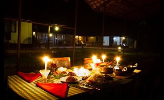 a table set up for a romantic dinner in the dark , with candles and plates of food at Emerald Isle